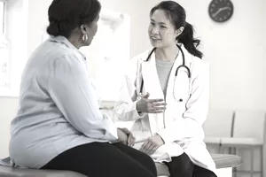 Una mujer de mediana edad está hablando con un asistente médico.