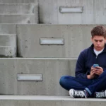 Adolescente que usa el teléfono celular para enviar un mensaje