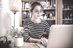 在家使用筆記本電腦工作的年輕女性